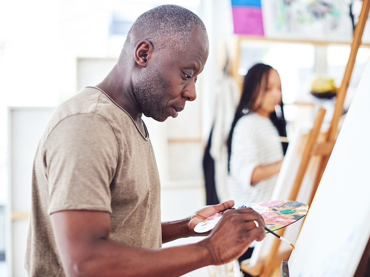 Middle aged man painting on canvas