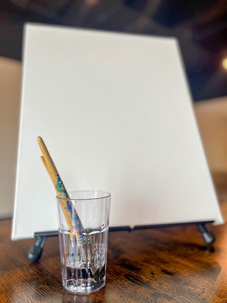 Closeup of blank painting canvas and brushes